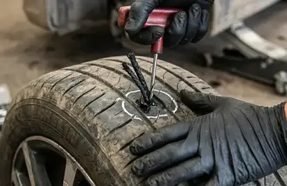 Technician carrying out a puncture repair on a car tyre